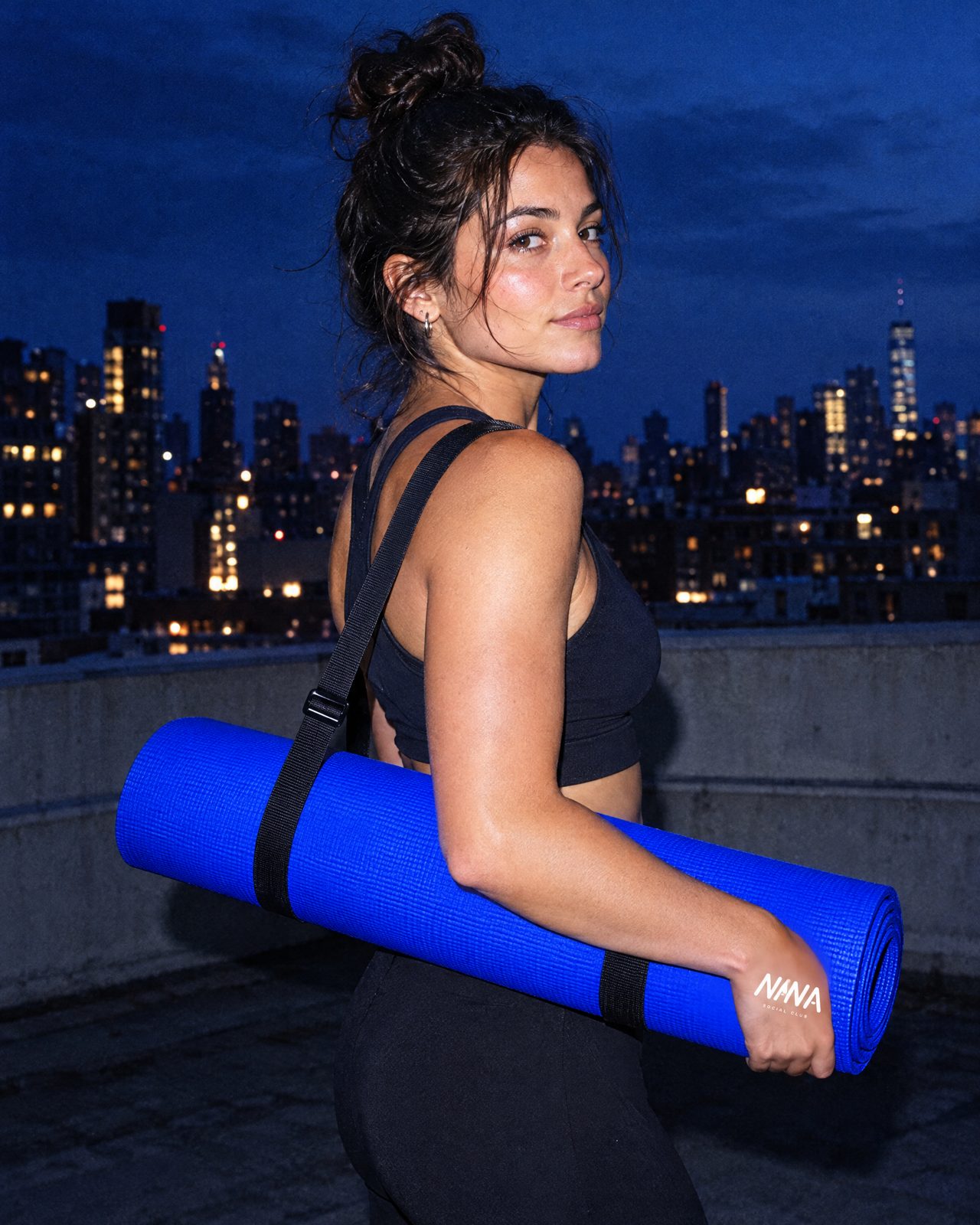 Yogamatte unterm Arm auf dem Rooftop